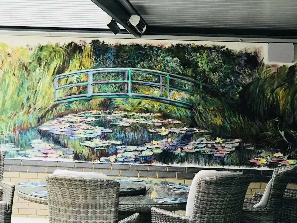 Hand-painted waterlily pond mural with bridge and lily pads in a garden setting
